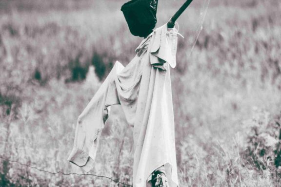 A scarecrow in an empty field.